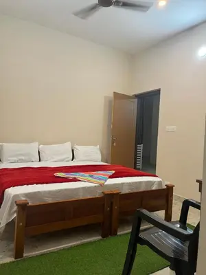 a bedroom with a bed with a red blanket at VARIYATH HOMESTAY THIRUNELLi in Thirunelli