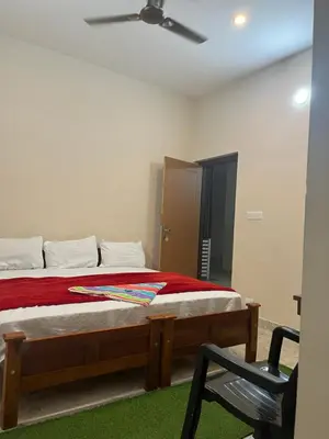 a bedroom with a bed with a fan and a chair at VARIYATH HOMESTAY THIRUNELLi in Thirunelli