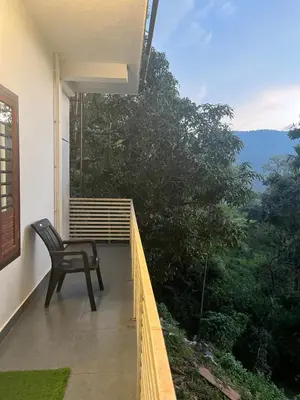 a chair sitting on the balcony of a house at VARIYATH HOMESTAY THIRUNELLi in Thirunelli