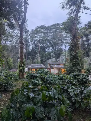a garden with a house in the background at Earthsong Luxury Pool Villa by Luxunlock Private Villas in Suntikoppa