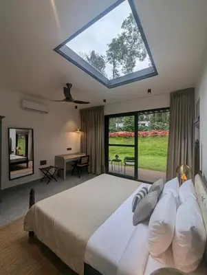 a bedroom with a large bed with a large skylight at Earthsong Luxury Pool Villa by Luxunlock Private Villas in Suntikoppa