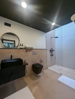 a bathroom with a shower and a sink and a mirror at Earthsong Luxury Pool Villa by Luxunlock Private Villas in Suntikoppa