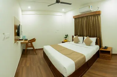 a hotel room with a bed and a television at FLY VIEW Airport Residency in Nedumbassery