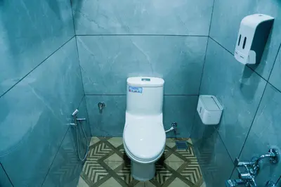 a bathroom with a toilet in a blue tiled wall at FLY VIEW Airport Residency in Nedumbassery