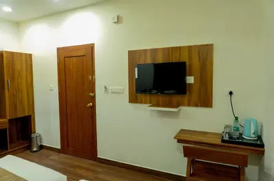 a room with a tv on the wall and a door at FLY VIEW Airport Residency in Nedumbassery