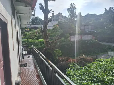 a balcony of a building with a view of a fountain at Shree Cottage in Madikeri