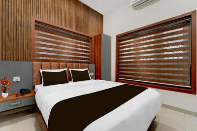 a bedroom with a large bed and two windows at Townhouse Thondayad Calicut Formerly Dream Casa in Kakkayam