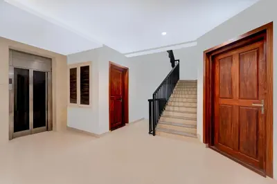 a room with a staircase and a wooden door at Townhouse Thondayad Calicut Formerly Dream Casa in Kakkayam