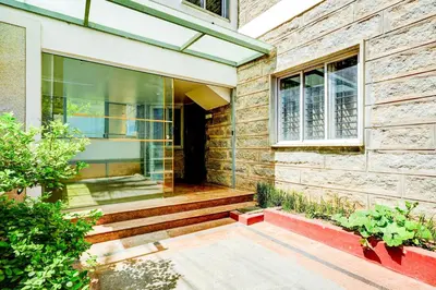 a brick house with a window and stairs at Super Collection O Rajkumar Road Formerly Stone Villa in Narasimharaja Puram