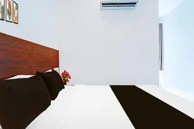 a bedroom with a bed with a wooden headboard at Super Hotel O Kaveri Road Mysore in Mysore