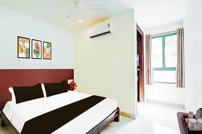 a bedroom with a large bed and a window at Super Hotel O Kaveri Road Mysore in Mysore