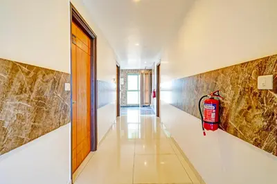 a hallway with a fire extinguisher on the wall at Super Hotel O Kaveri Road Mysore in Mysore
