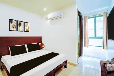 a bedroom with a large bed and a window at Super Hotel O Kaveri Road Mysore in Mysore
