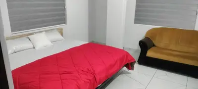 a bedroom with a red bed and a chair at Little home apartment in Kozhikode