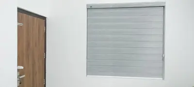 a window with a roller blind on a white wall at Little home apartment in Kozhikode