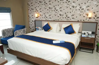 a bedroom with a large bed with blue and white pillows at Blue Diamond Residency in Perintalmanna
