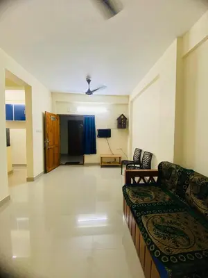 a living room with a couch and a stage at 1 BHK flat in Guruvayur - Sooryamadhavam Apartments-only for pilgrims in Guruvāyūr