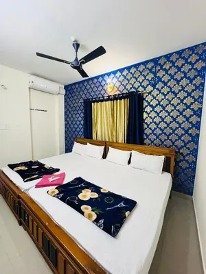 a bedroom with a large bed with a blue wall at 1 BHK flat in Guruvayur - Sooryamadhavam Apartments-only for pilgrims in Guruvāyūr