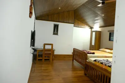 a room with two beds and a table in it at Sidharth Resort, Vadavannur in Kollengode