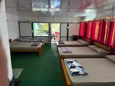 a room with four beds and red curtains at Sidharth Resort, Vadavannur in Kollengode