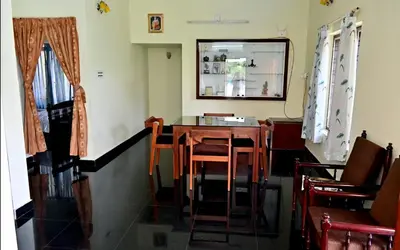 a dining room with a table and chairs and a mirror at Ceema Homestay in Ernakulam