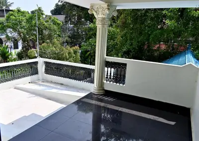 a porch with a white fence and a column at Ceema Homestay in Ernakulam