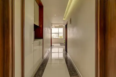 a hallway with white walls and a white floor at Hotel J N Stay Mysore - 12 Minutes to Mysore Palace in Mysore