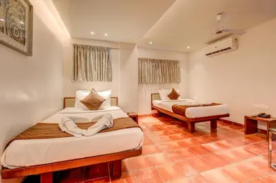 a bedroom with two beds in a room at Hotel J N Stay Mysore - 12 Minutes to Mysore Palace in Mysore