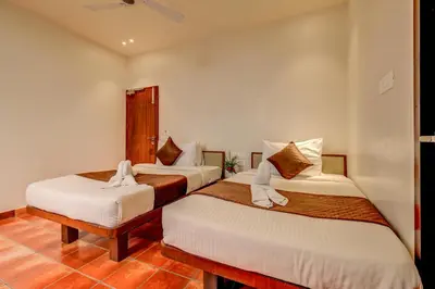a hotel room with two beds with white sheets at Hotel J N Stay Mysore - 12 Minutes to Mysore Palace in Mysore