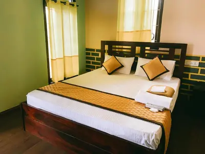 a bedroom with a large bed with a wooden headboard at Hilltown Villa Holiday's in Ooty