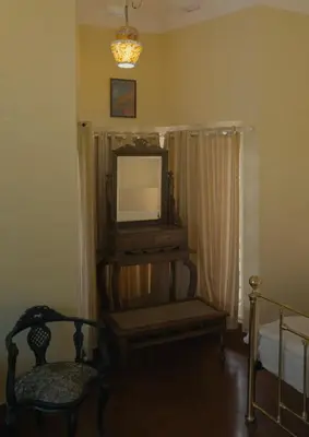 a living room with a tv and a chair at Vintage Coffee Estate 3 Bedrooms 1 Cottage in Wayanad