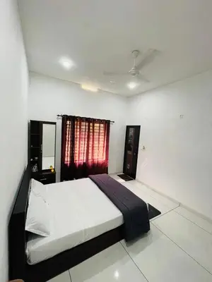 a bedroom with a bed and a red window at aphrodite home stay in Pinangode