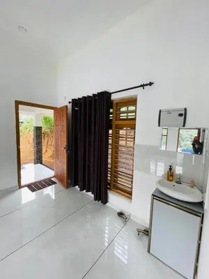 a bathroom with a sink and a toilet in a room at aphrodite home stay in Pinangode
