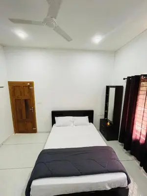 a bedroom with a large bed in a room at aphrodite home stay in Pinangode