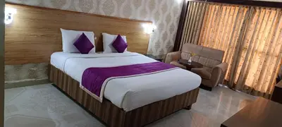 a bedroom with a large bed with purple pillows at The Monarch in Ooty