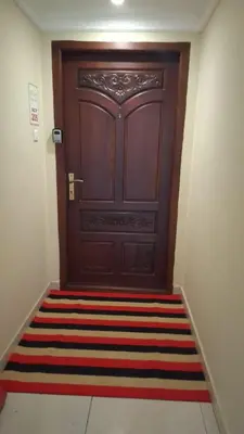 a large wooden door with a rug in front of it at Atlas Celestial Park in Nedumbassery