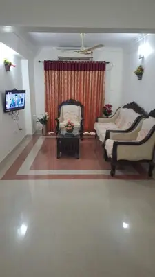 a living room with two chairs and a tv at Atlas Celestial Park in Nedumbassery