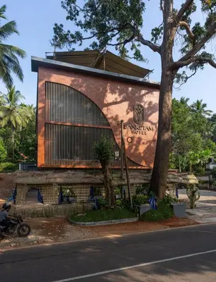 a building with a large window on the side of it at Sanketam Motel in Calicut