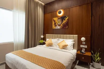 a bedroom with a large bed with a wooden wall at Sanketam Motel in Calicut