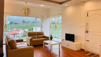 a living room with a couch and a tv and a window at Away From Home - 3 - Rooms In Ooty, Home Stay Ooty in Ooty