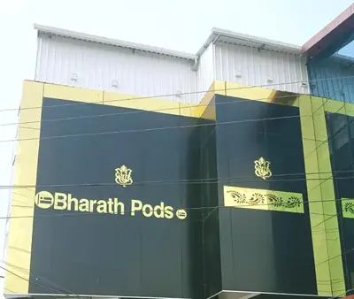 a building with a sign on the side of it at Bharath Pods in Coimbatore