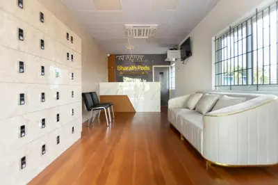 a living room with a couch and a table at Bharath Pods in Coimbatore