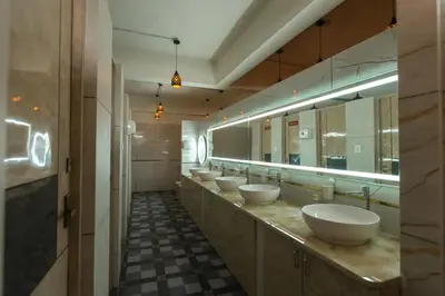 a bathroom with a row of sinks and mirrors at Bharath Pods in Coimbatore
