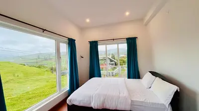 a bedroom with a bed and a large window at Away From Home - 6 - Rooms In Ooty, Home Stay Ooty in Ooty