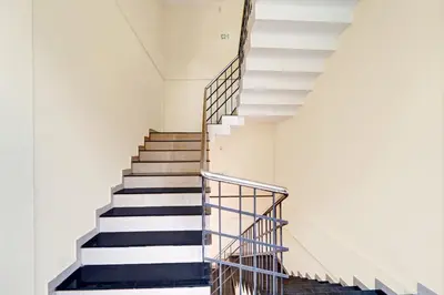 a staircase in a building with black and white at Super Hotel O West Hill near Mietra Hospital in Calicut
