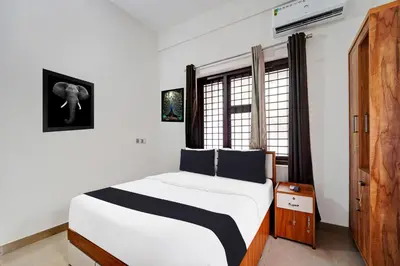 a bedroom with a large bed and a window at Super Hotel O West Hill near Mietra Hospital in Calicut