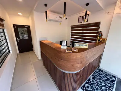 a bar with a wooden counter in a room at Ashtapadi Inn in Guruvāyūr