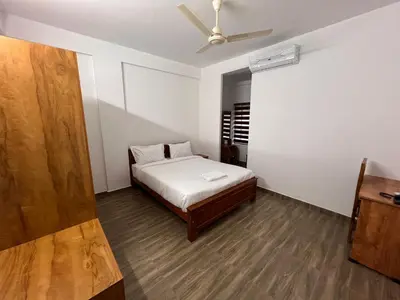 a bedroom with a bed and a ceiling fan at Ashtapadi Inn in Guruvāyūr