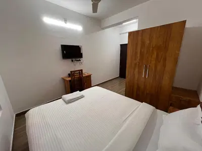 a bedroom with a bed and a television in it at Ashtapadi Inn in Guruvāyūr