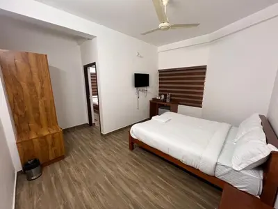 a bedroom with a bed and a television in it at Ashtapadi Inn in Guruvāyūr